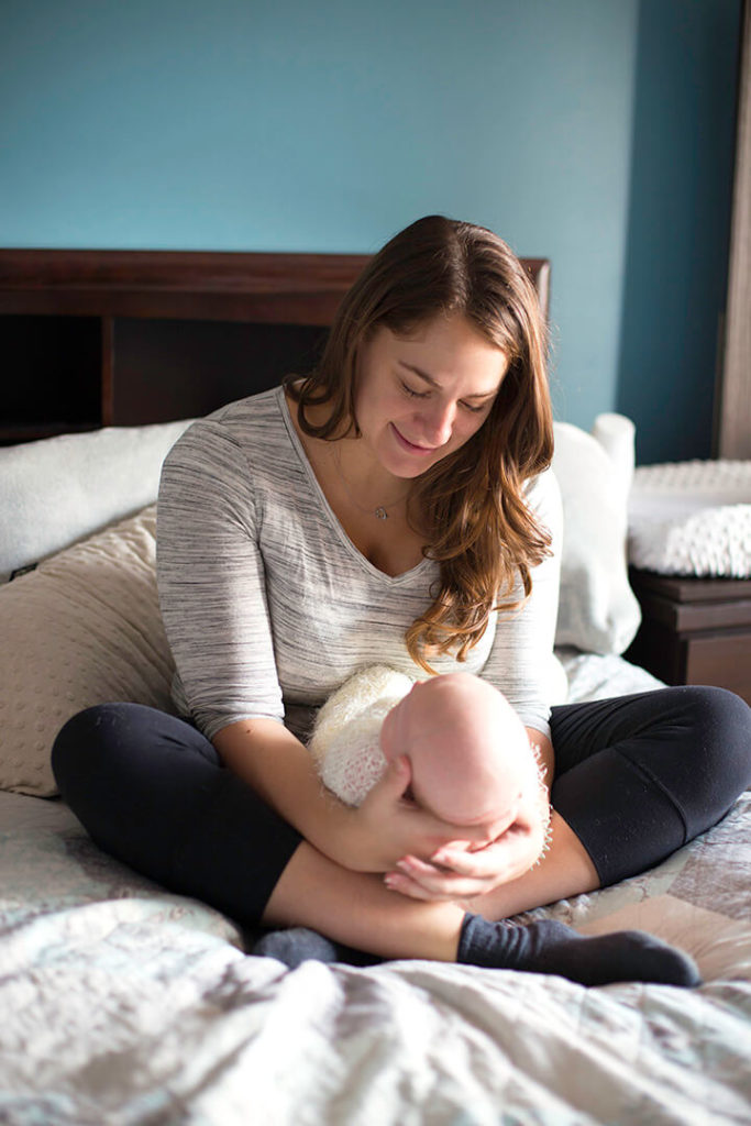 candid shot of mother and her baby in master bedroom